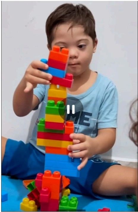 Criança montando torre com blocos coloridos em sessão terapêutica