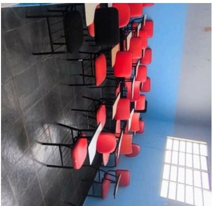 Sala de aula com cadeiras vermelhas